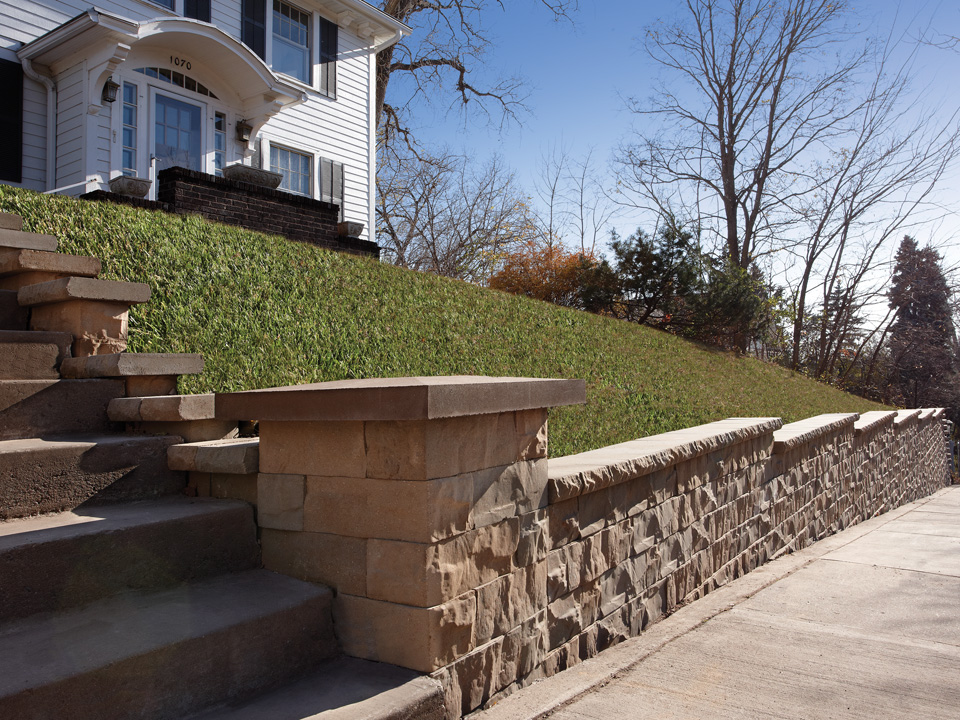 Raised front lawn supported by Brisa retaining walls, featuring a stone block stairway
